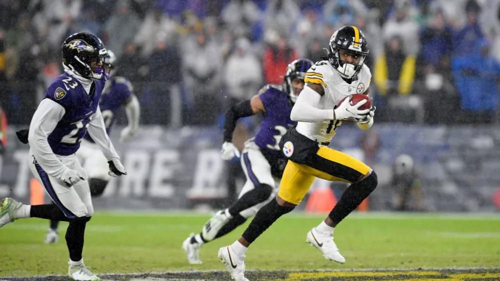 Steelers wide receiver Dionte Johnson (18) runs away from Ravens defenders