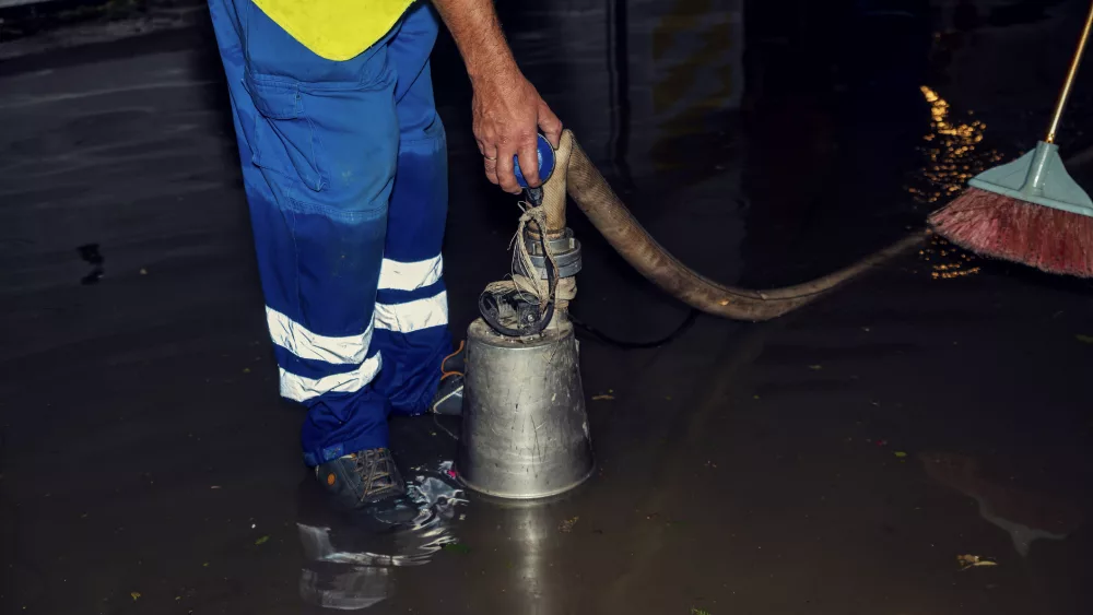 Emergency service pumping up the water in parking lot. It has been flooded after heavy summer rain.