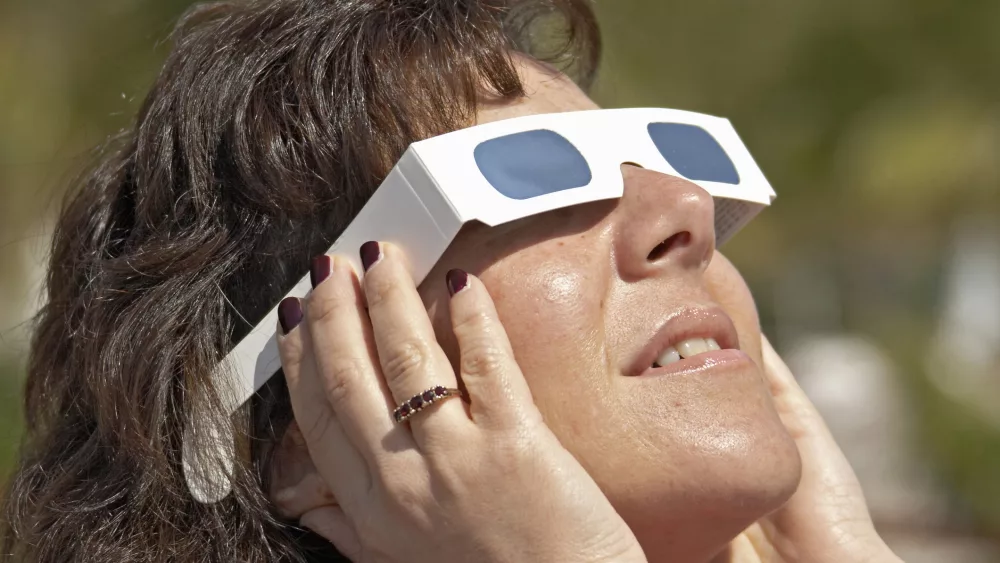 Woman looking at sun through special mylar solar viewing glasses at Total Eclipse of the Sun from Side in southern Turkey, 29 March 2006