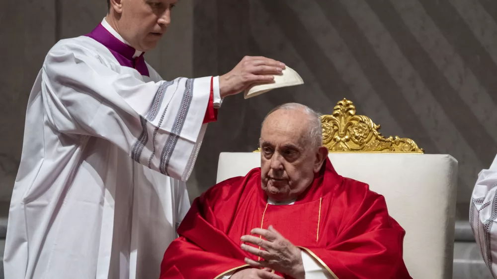 Monsignor Krzysztof Marcjanowicz puts the skull cap on Pope Francis during the liturgy of the passion on Good Friday in St. Peter's Basilica at The Vatican, Friday, Mar. 29, 2024. (AP Photo/Domenico Stinellis)
