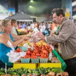 A vendor sells produce to a customer at a farmers market in Baltimore,MD: A vendor sells produce to a customer at a farmers market in Baltimore,MD. (Photo by: Edwin Remsberg / VWPics/Universal Images Group via Getty Images)