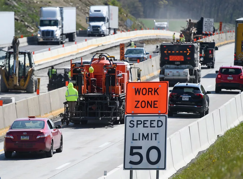 Greenwich Township, PA - April 27: Cars and trucks go past a crew painting a line on interstate 78 with a "Work Zone" and "Speed Limit 50" sign in the foreground. During a press conference held by PennDOT next to Interstate 78 in Greenwich township Tuesday morning April 27, 2021 where they highlighted the need for safety around work zones on roads. (Photo by Ben Hasty/MediaNews Group/Reading Eagle via Getty Images)
