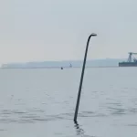 IMG_2709: A lightpole, still attached to the Key Bridge that is in the Patapsco River, pokes through the water line. (Image Credit: 
Phil Yacuboski
Anchor/Reporter
WBAL-AM 1090 and FM 101.5)