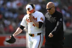 Baltimore Orioles relief pitcher Craig Kimbrel, left, leaves alongside trainer Brian Ebel, right, during the ninth inning of a baseball game against the Oakland Athletics, Sunday, April 28, 2024, in Baltimore. (AP Photo/Nick Wass)