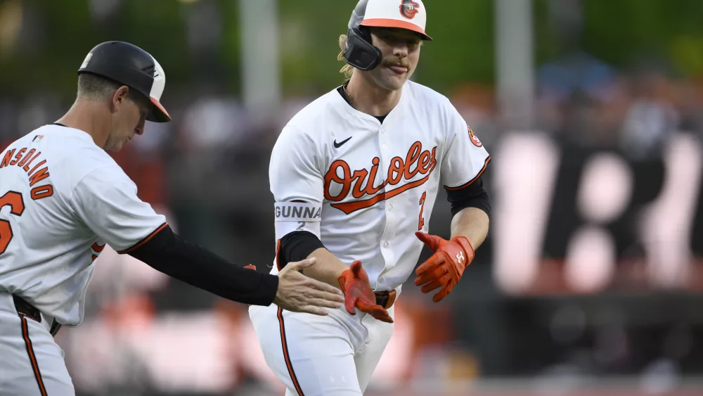 Baltimore Orioles' Gunnar Henderson, right, celebrates after his home run with third base coach Tony Mansolino, left, during the first inning of a baseball game against the New York Yankees, Monday, April 29, 2024, in Baltimore. (AP Photo/Nick Wass)