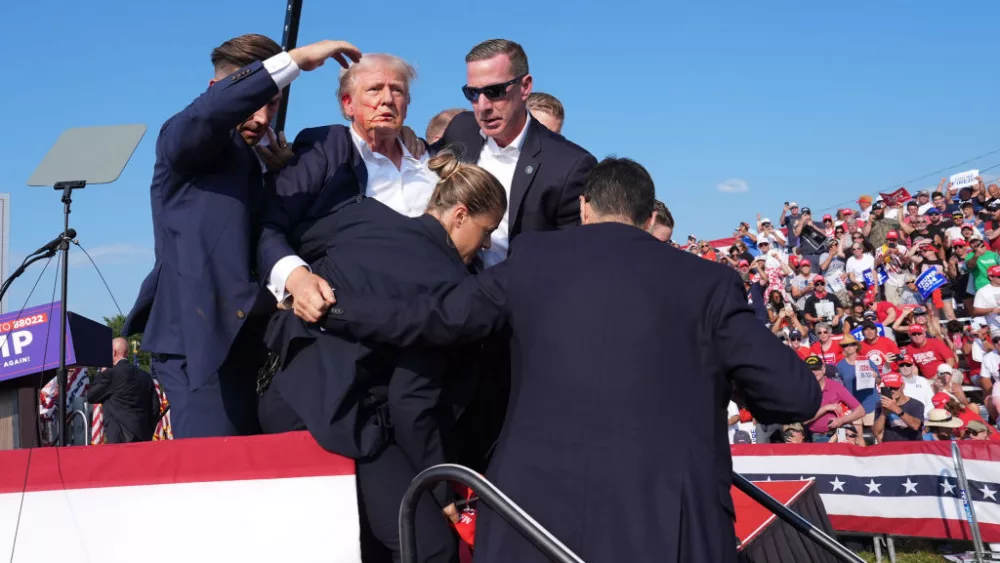 Former president Donald Trump is assisted offstage during a campaign rally.