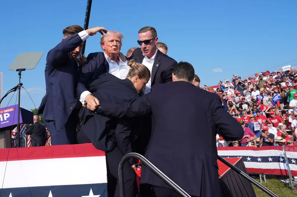 Former president Donald Trump is assisted offstage during a campaign rally.