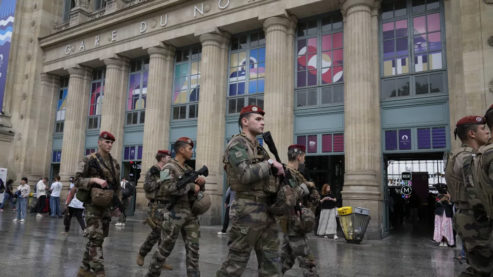 Soldiers patrol outside Gare du Nord train station at the 2024 Summer Olympics, Friday, July 26, 2024, in Paris, France. Hours away from the grand opening ceremony of the Olympics, high-speed rail traffic to the French capital was severely disrupted on Friday by what officials described as "criminal actions" and sabotage. (AP Photo/Mark Baker)