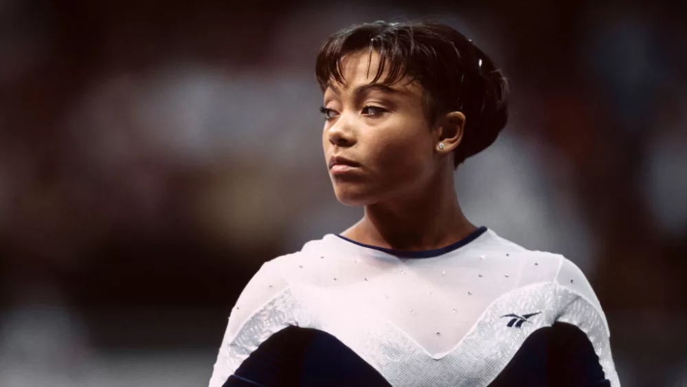 UNIONDALE, NY - JULY 1998: Dominique Dawes of the United States competes in the Gymnastics competition of the Goodwill Games which took place from July 19 - August 2, 1998 in New York, New York. The gymnastics venue was the Nassau Veterans Memorial Coliseum in Uniondale, New York.. (Photo by David Madison/Getty Images)