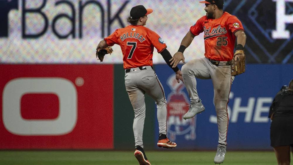 Baltimore Orioles' Jackson Holliday (7) celebrates with Anthony Santander (25) at the end of a baseball game against the Cleveland Guardians in Cleveland, Saturday, Aug. 3, 2024. (AP Photo/Phil Long)