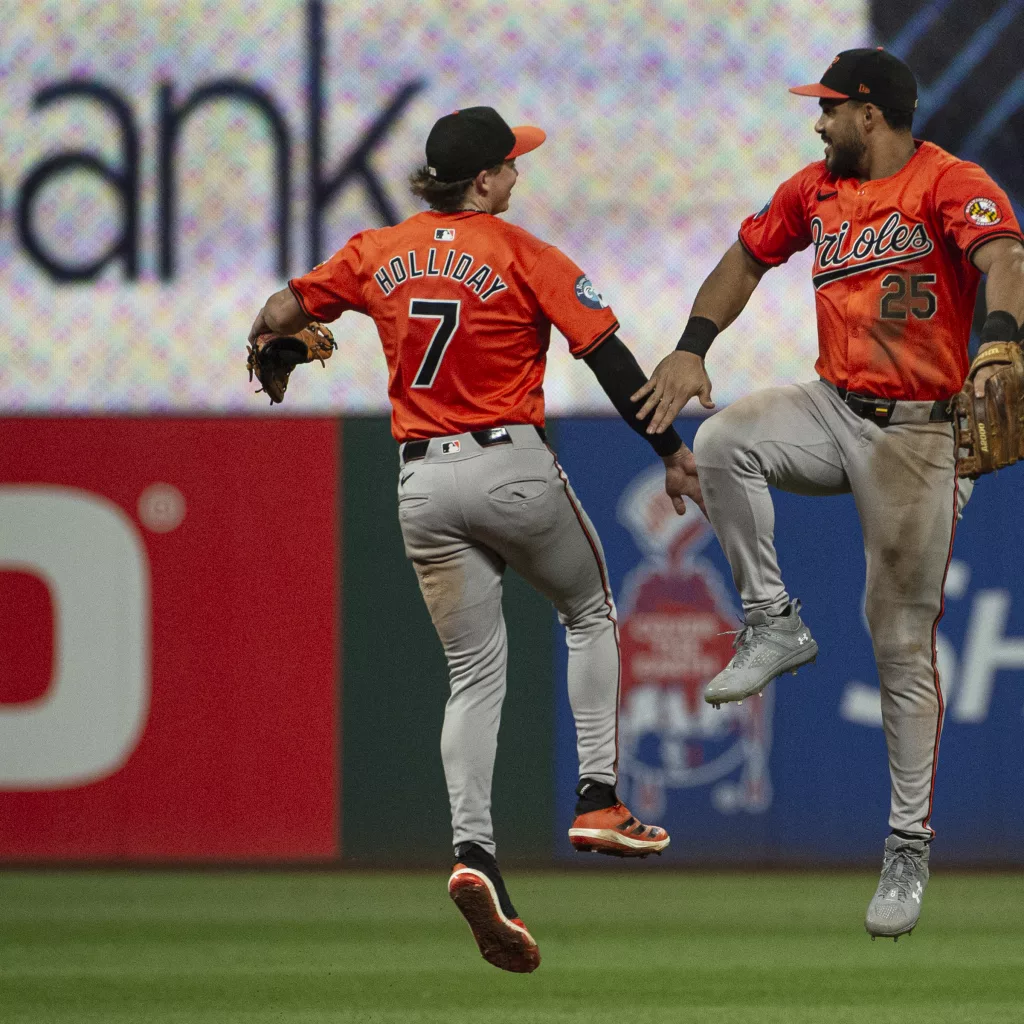 Baltimore Orioles' Jackson Holliday (7) celebrates with Anthony Santander (25) at the end of a baseball game against the Cleveland Guardians in Cleveland, Saturday, Aug. 3, 2024. (AP Photo/Phil Long)