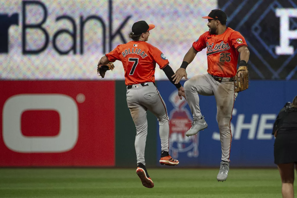 Baltimore Orioles' Jackson Holliday (7) celebrates with Anthony Santander (25) at the end of a baseball game against the Cleveland Guardians in Cleveland, Saturday, Aug. 3, 2024. (AP Photo/Phil Long)