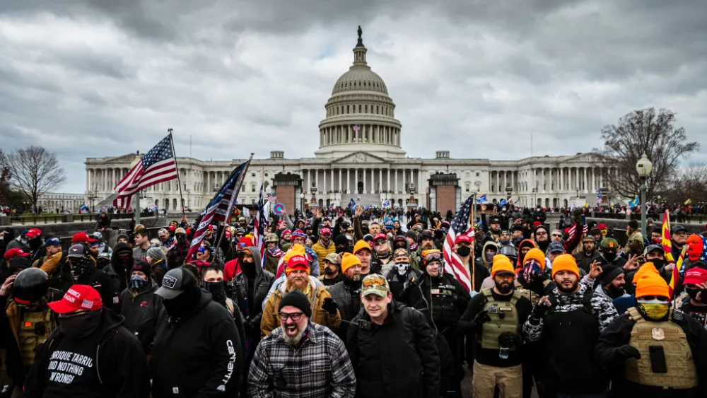 WASHINGTON, DC - JANUARY 06: Pro-Trump protesters, including Proud Boys leader Joe Biggs, (plaid shirt at bottom center of frame,) gather in front of the U.S. Capitol Building on January 6, 2021 in Washington, DC. A pro-Trump mob stormed the Capitol, breaking windows and clashing with police officers. Trump supporters gathered in the nation's capital today to protest the ratification of President-elect Joe Biden's Electoral College victory over President Trump in the 2020 election. (Photo by Jon Cherry/Getty Images)