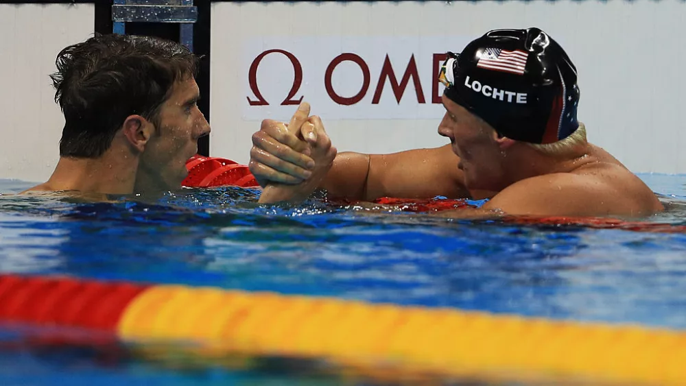 RIO DE JANEIRO, BRAZIL - AUGUST 11: Michael Phelps of the United States shakes hands with Ryan Lochte of the United States after winning the Men's 200m Individual Medley Final on Day 6 of the Rio 2016 Olympic Games at the Olympic Aquatics Stadium on August 11, 2016 in Rio de Janeiro, Brazil. (Photo by Mike Ehrmann/Getty Images)