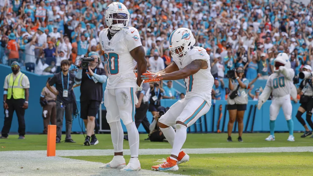 Miami Dolphins wide receiver Tyreek Hill (10) holds his hands behind his back as if he is handcuffed as Miami Dolphins wide receiver Jaylen Waddle (17) unlocks them after Hill scores against the Jacksonville Jaguars in the second half during an NFL football game at Hard Rock Stadium in Miami Gardens, Florida, on Sunday, Sept. 8, 2024. (Al Diaz/Miami Herald via AP) - After his traffic stop in Miami on Sunday, Tyreek Hill said that as a youngster he received ‘the talk’ about what to do when pulled over by police. He knew to heed the instructions passed down in Black families for generations. Keep your hands in sight. Avoid sudden movements. Don’t talk back. And follow instructions without error or delay. Miami-Dade Police ordered the Miami Dolphins star wide receiver out of his vehicle, handcuffing and placing him face down on a street outside the team’s stadium. Hill said he was stopped for speeding and reckless driving before the Dolphins’ first game of the season. His interaction with police captured in now-viral cellphone video appeared to escalate to the type of incident that often prompts protests and claims of discriminatory policing.