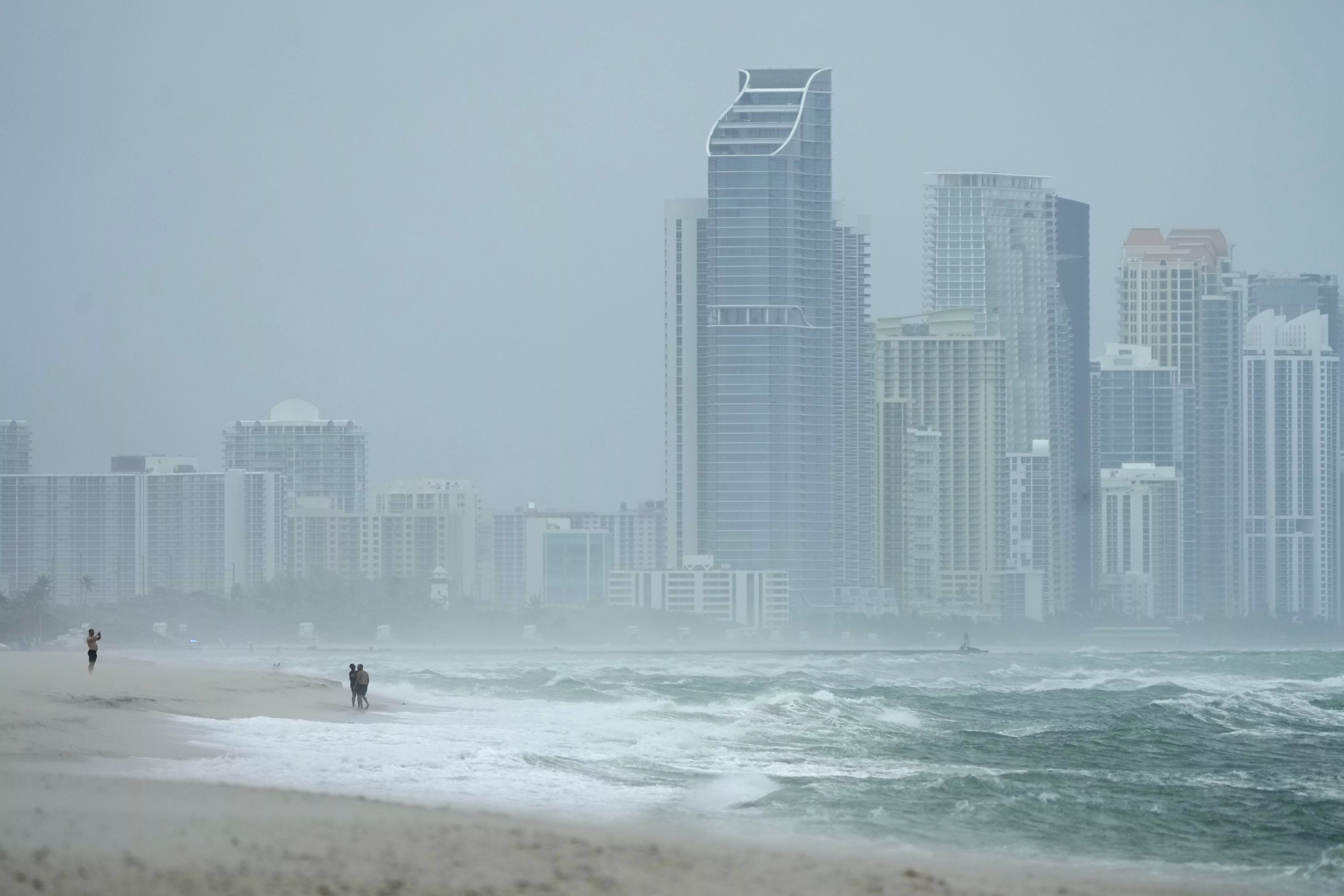 The city of Sunny Isles Beach, Fla., is seen from Surfside, Fla., as the outer bands of Hurricane Milton kick up the sand, Wednesday, Oct. 9, 2024. (AP Photo/Wilfredo Lee)