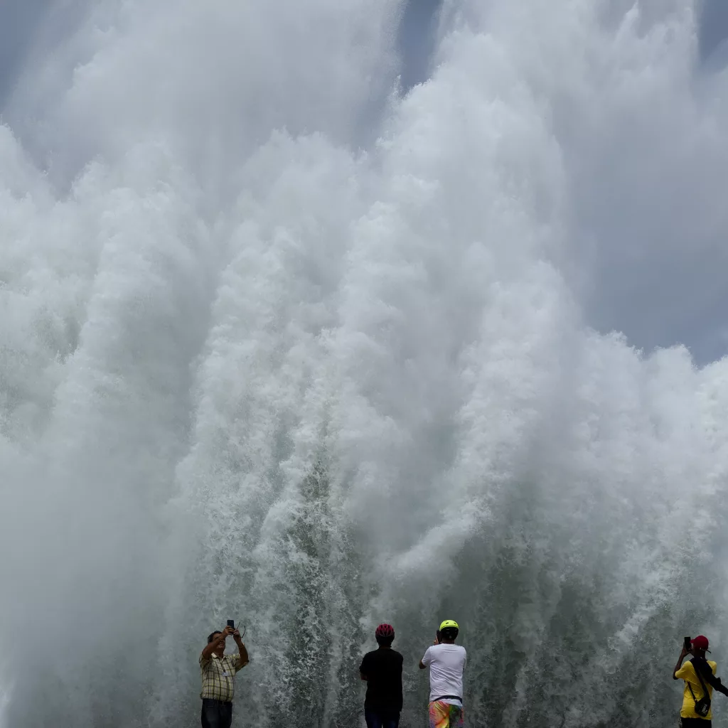 People take photos of the spray from waves crashing against the Malecon seawall, brought by the passing of Hurricane Milton in the Gulf of Mexico, in Havana, Cuba, Wednesday, Oct. 9, 2024. (AP Photo/Ramon Espinosa)