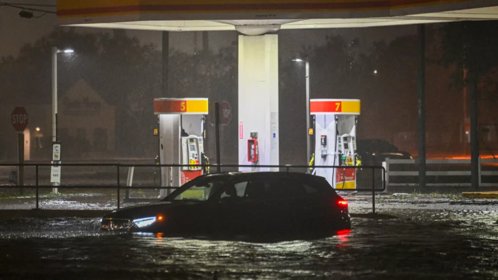 A vehicle is stranded on a water-flooded street