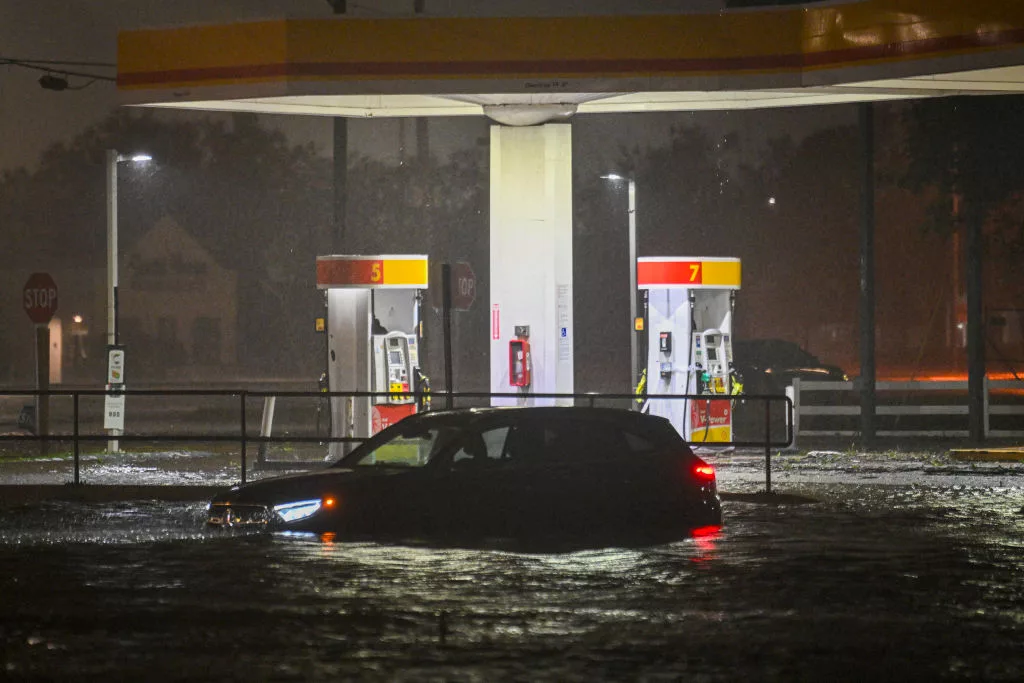 A vehicle is stranded on a water-flooded street