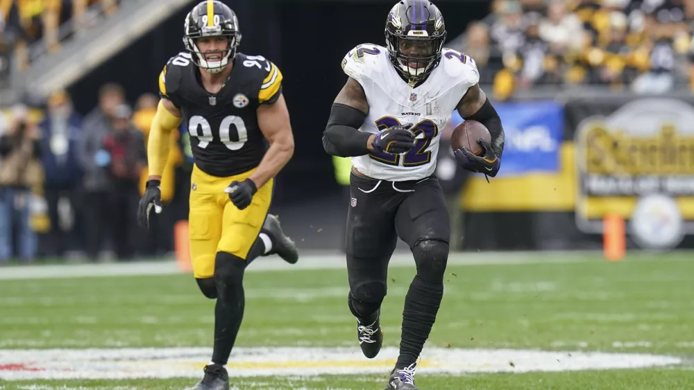 Baltimore Ravens running back Derrick Henry (22) runs with the ball in front of Pittsburgh Steelers linebacker T.J. Watt (90) during the first half of an NFL football game, Sunday, Nov. 17, 2024, in Pittsburgh. (AP Photo/Matt Freed)