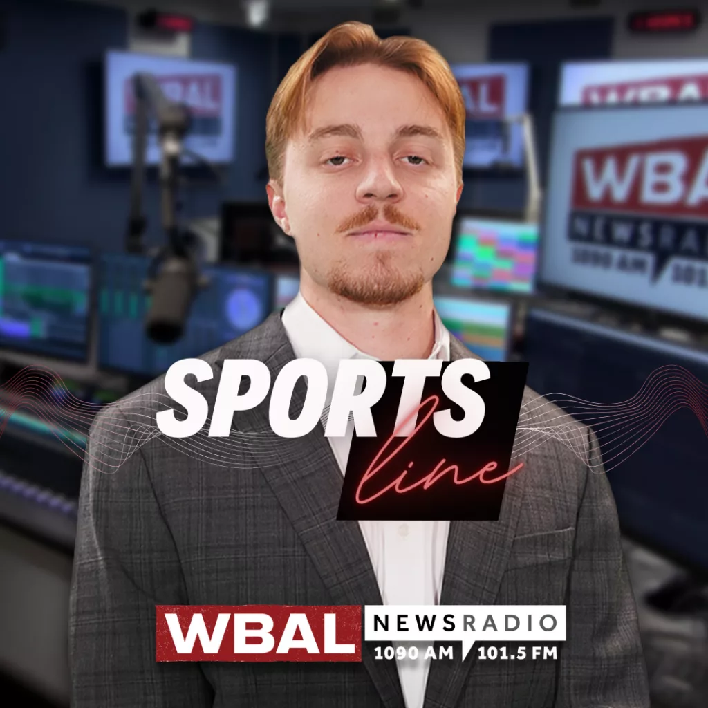 WBAL NewsRadio's Nick Testoni, reporter and host of Saturday's talk show, Sportsline. Nick stands in the WBAL Radio studio in a sports jacket with a straight face.