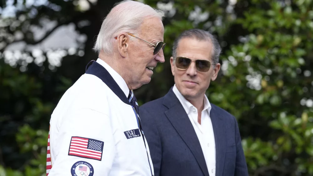 FILE - President Joe Biden, wearing a Team USA jacket and walking with his son Hunter Biden, heads toward Marine One on the South Lawn of the White House in Washington, July 26, 2024. (AP Photo/Susan Walsh, File)