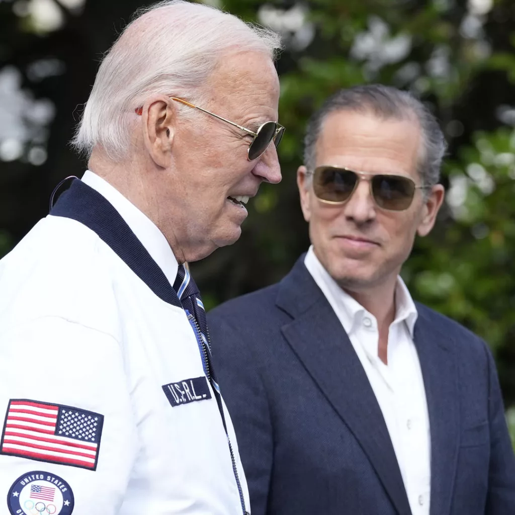 FILE - President Joe Biden, wearing a Team USA jacket and walking with his son Hunter Biden, heads toward Marine One on the South Lawn of the White House in Washington, July 26, 2024. (AP Photo/Susan Walsh, File)