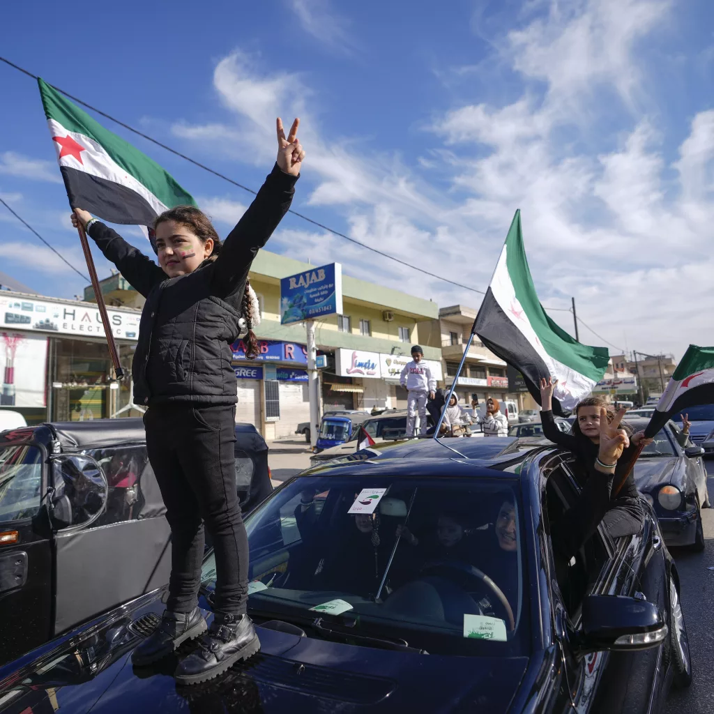 Syrians celebrate the fall of Bashar Assad's government in the town of Bar Elias, Lebanon, near the border with Syria, Sunday, Dec. 8, 2024. (AP Photo/Hassan Ammar)