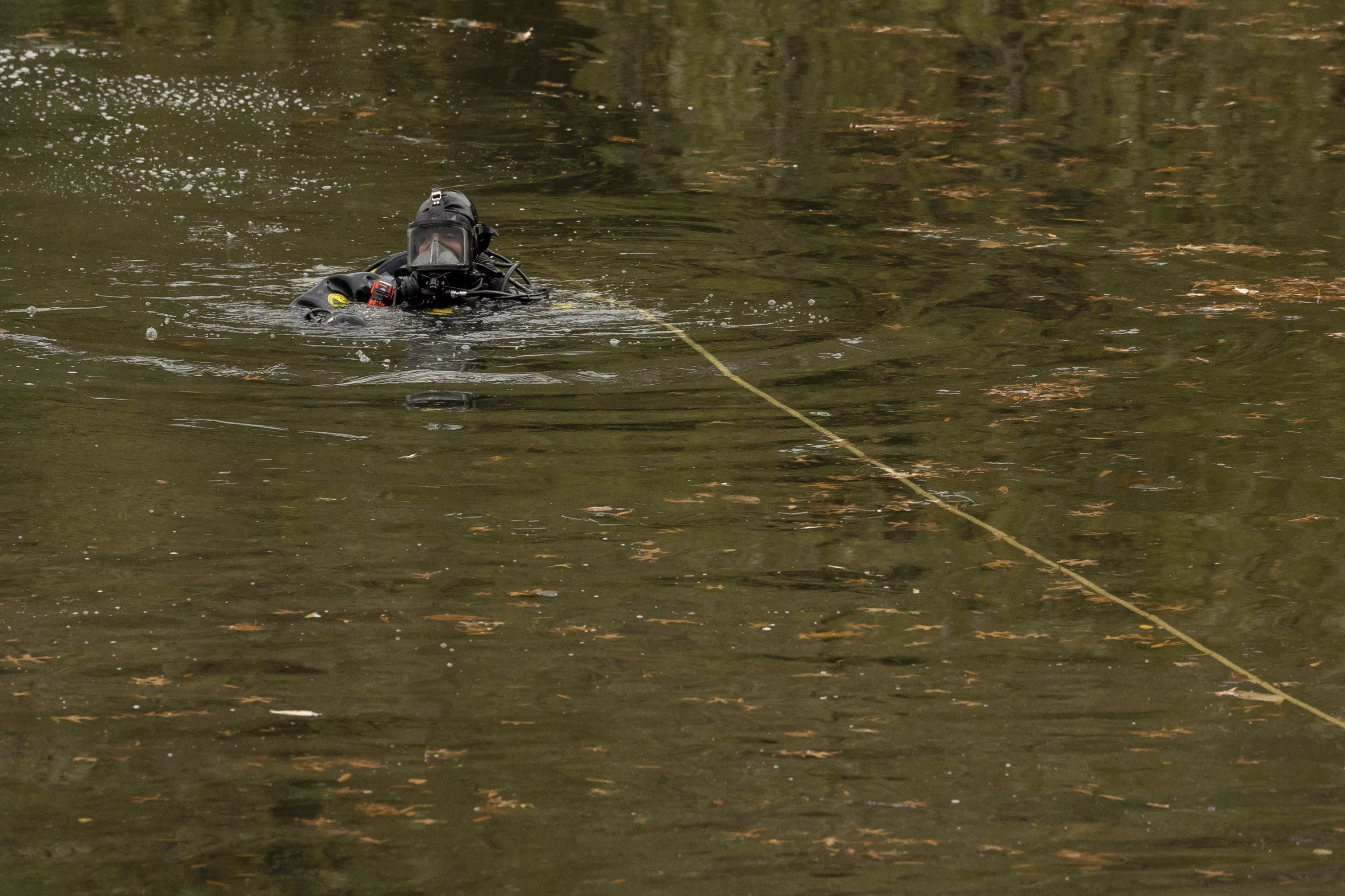 NYPD officers in diving suits search a lake in Central Park, Monday, Dec. 9, 2024, in New York. (AP Photo/Yuki Iwamura)