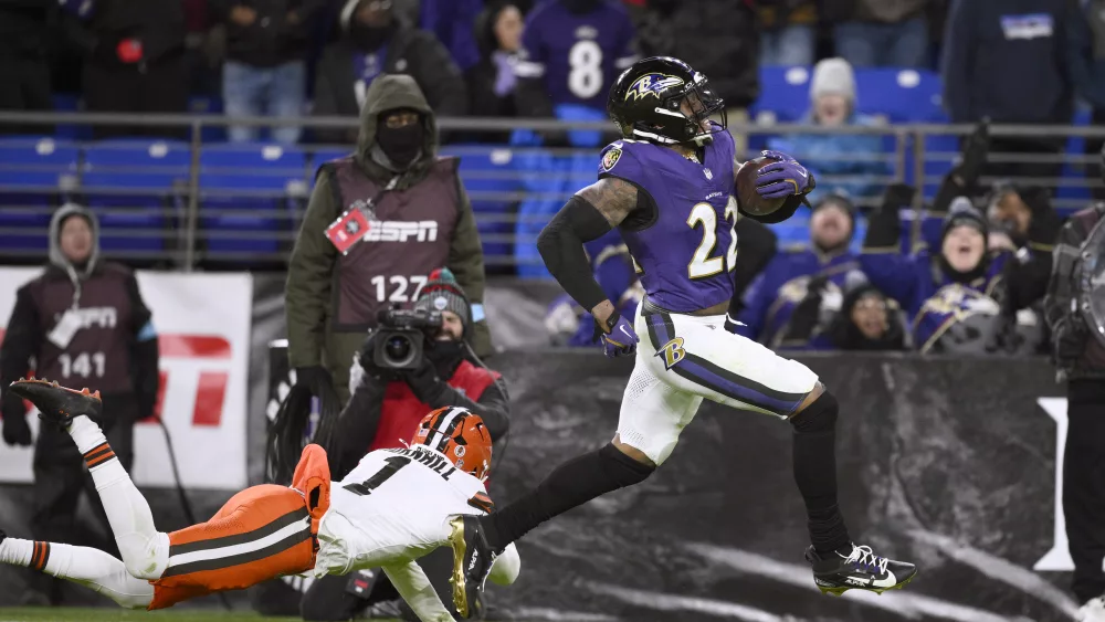 Baltimore Ravens running back Derrick Henry, right, scores past Cleveland Browns safety Juan Thornhill (1) on a 43-yard touchdown run during the second half of an NFL football game Saturday, Jan. 4, 2025, in Baltimore. (AP Photo/Nick Wass)