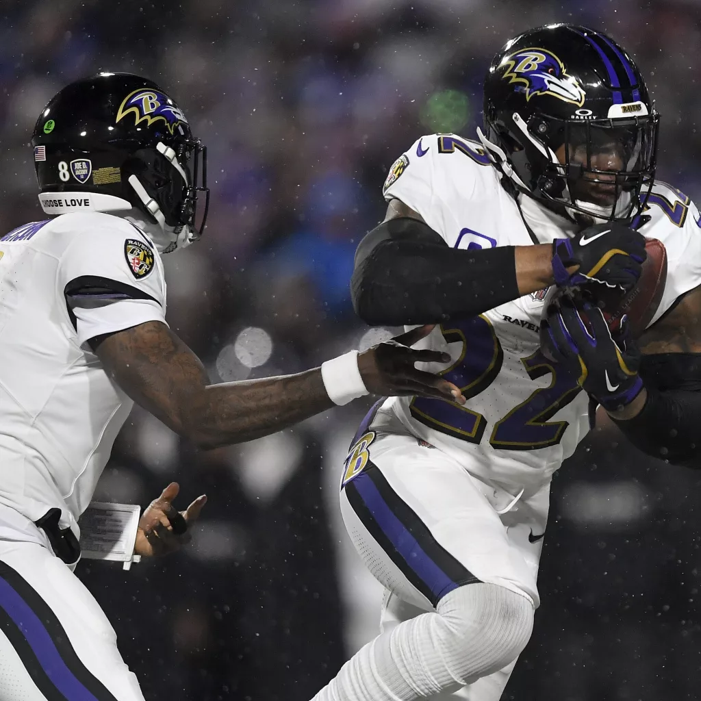 Baltimore Ravens quarterback Lamar Jackson (8) hands off the ball to running back Derrick Henry (22) during the first quarter of an NFL divisional playoff football game against the Buffalo Bills, Sunday, Jan. 19, 2025, in Orchard Park, N.Y. (AP Photo/Adrian Kraus)