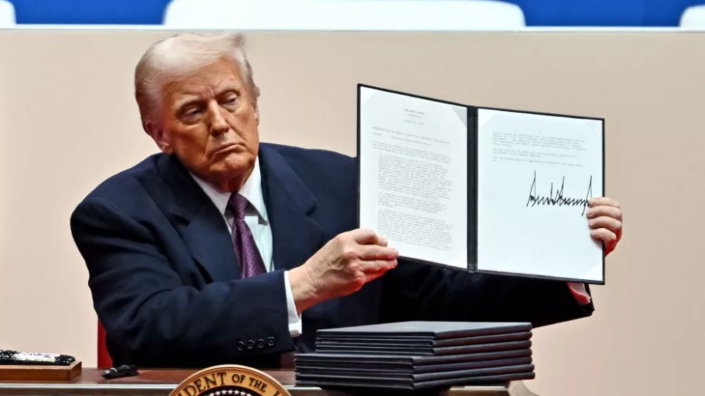 President Donald Trump signs executive orders during the inaugural parade.