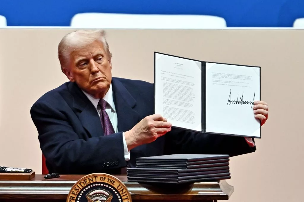 President Donald Trump signs executive orders during the inaugural parade.