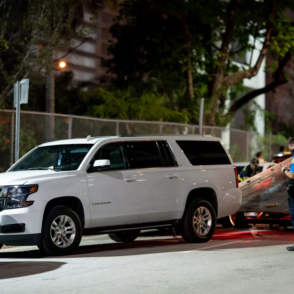 Police officer supervising Chevy Suburban illegally parked being towed