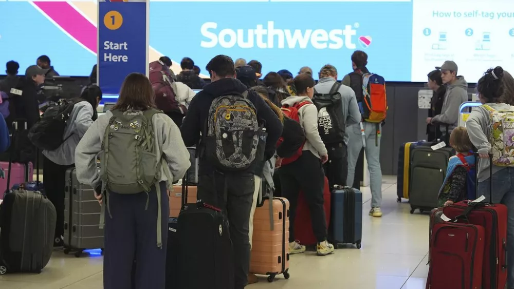 FILE - Travelers wait at the check-in counter for Southwest Airlines in Denver International Airport Thursday, Dec. 19, 2024, in Denver. (AP Photo/David Zalubowski, File)