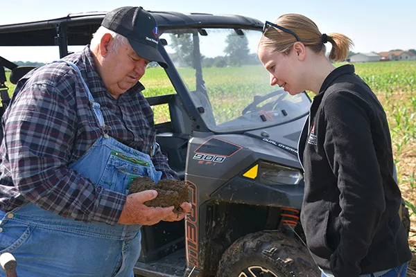 Dave Brandt shows soil to Stephanie Karhoff, Ohio State University.