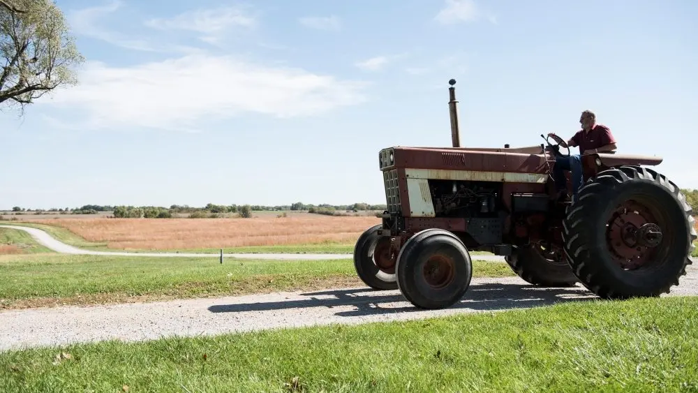 farmer-driving-tractor-on-rural-road-missouri-us-2026-03-10-02-06-30-utc