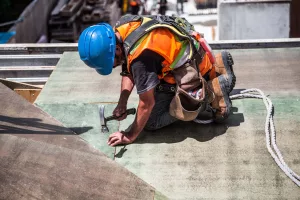 canva-man-wearing-blue-hard-hat-using-hammer