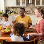 young-christian-family-of-four-praying-before-dinner