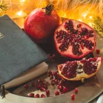 fruits-and-vegetables-for-harvesting-still-life-bible-and-pomegranate-on-an-iron-plate-in-the-branches-of-the-christmas-tree