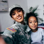 smiling-african-american-daughter-and-soldier-in-military-uniform-taking-selfie-at-home