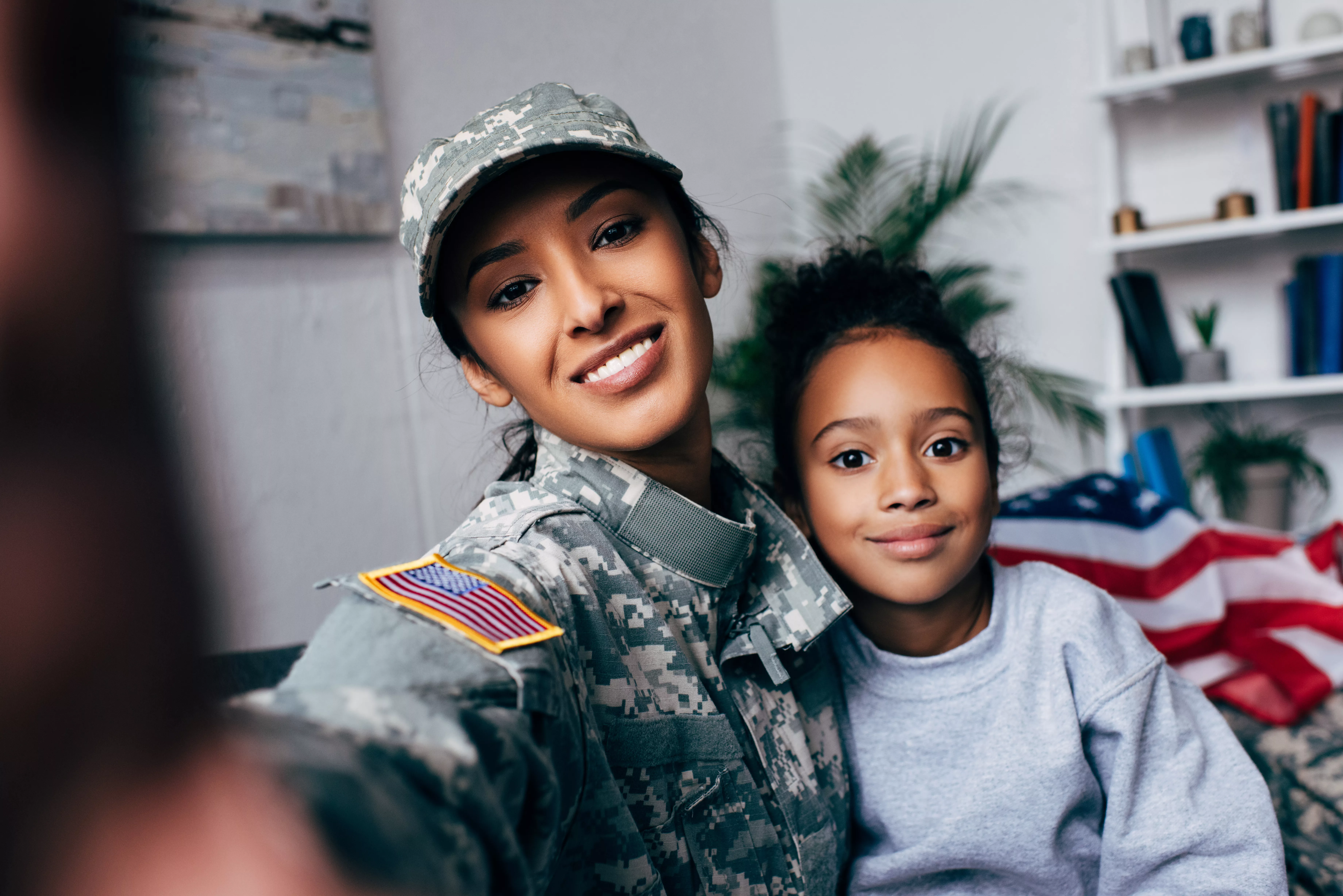 smiling-african-american-daughter-and-soldier-in-military-uniform-taking-selfie-at-home