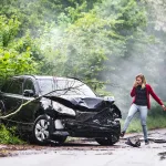an-angry-young-woman-with-smartphone-by-the-damaged-car-after-a-car-accident