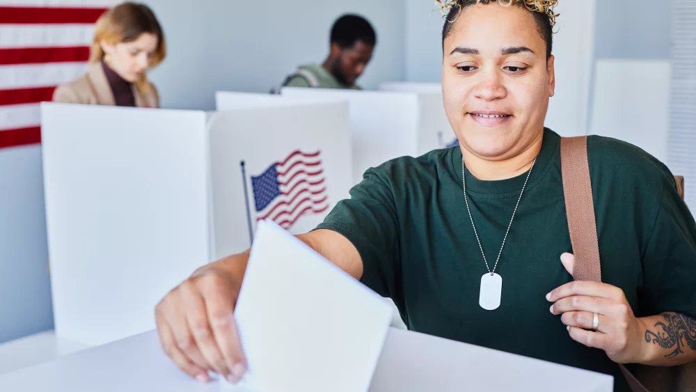 black-woman-putting-voting-ballot-in-bin
