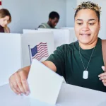 black-woman-putting-voting-ballot-in-bin
