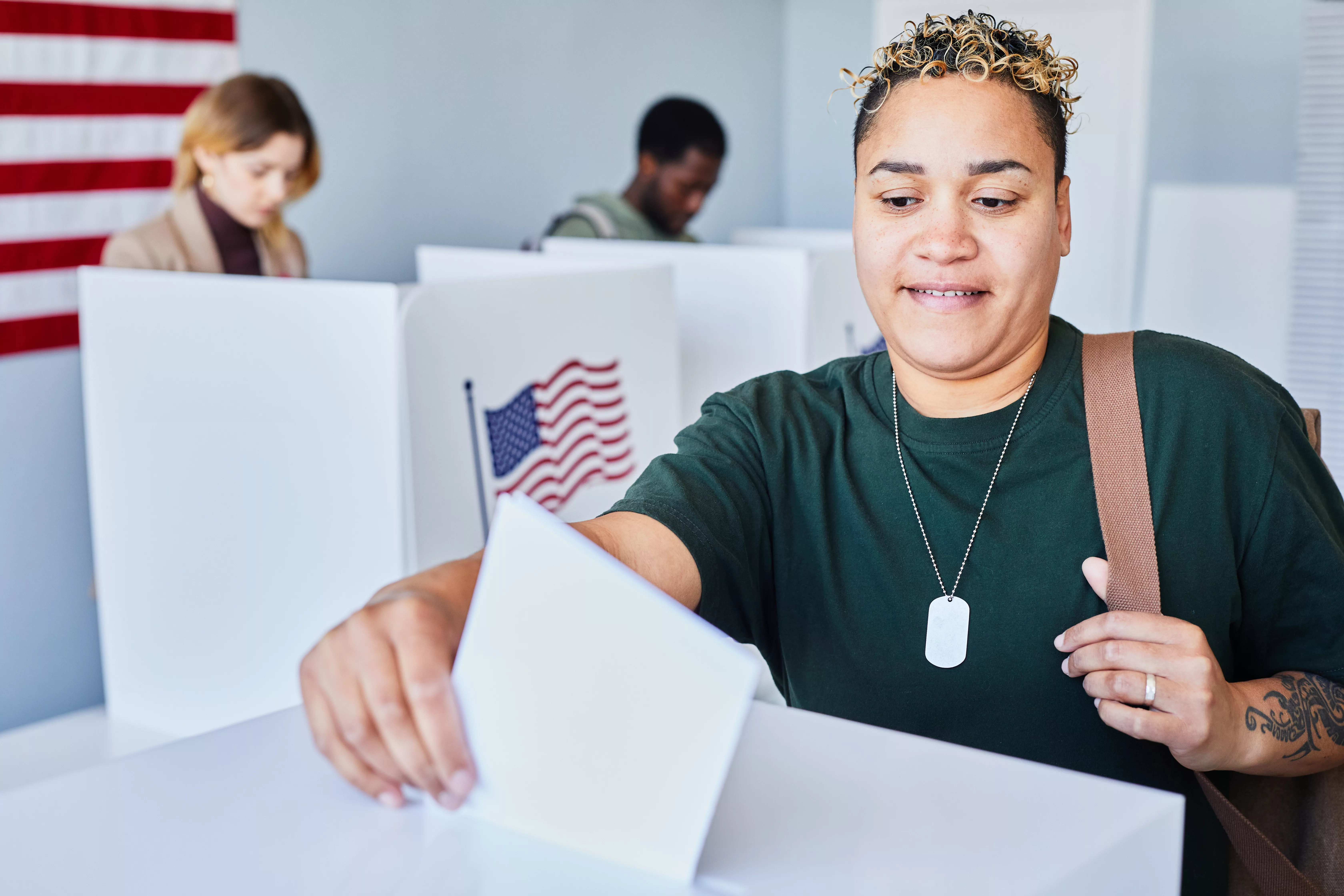 black-woman-putting-voting-ballot-in-bin