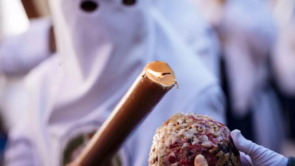 person-in-white-traditional-mask-holding-a-decorative-scepter-at-a-cultural-event