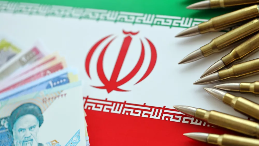 many-bullets-and-iranian-rials-money-bills-on-flag-of-islamic-republic-of-iran