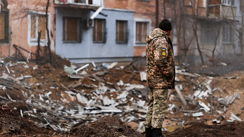 a-ukrainian-serviceman-stands-next-to-the-shelling-of-a-civilian-building-in-kherson-by-the-russian