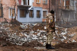 a-ukrainian-serviceman-stands-next-to-the-shelling-of-a-civilian-building-in-kherson-by-the-russian
